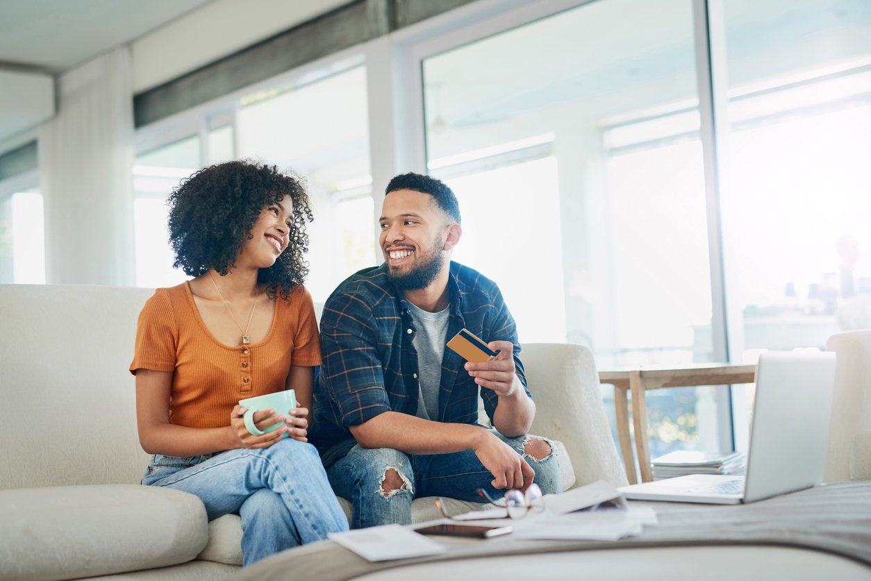 A smiling couple manages their Radiant Even-Up Savings account, enjoying automatic round-ups that boost their savings effortlessly.