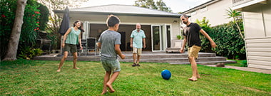 Family playing soccer in front of their new home. Family playing soccer in front of their new home.