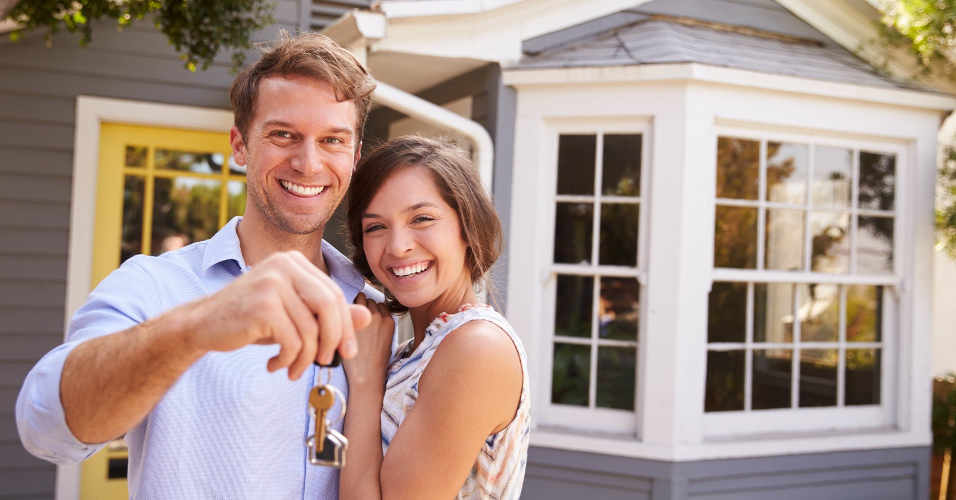 First time homeowners outside their new home financed by Radiant Credit Union