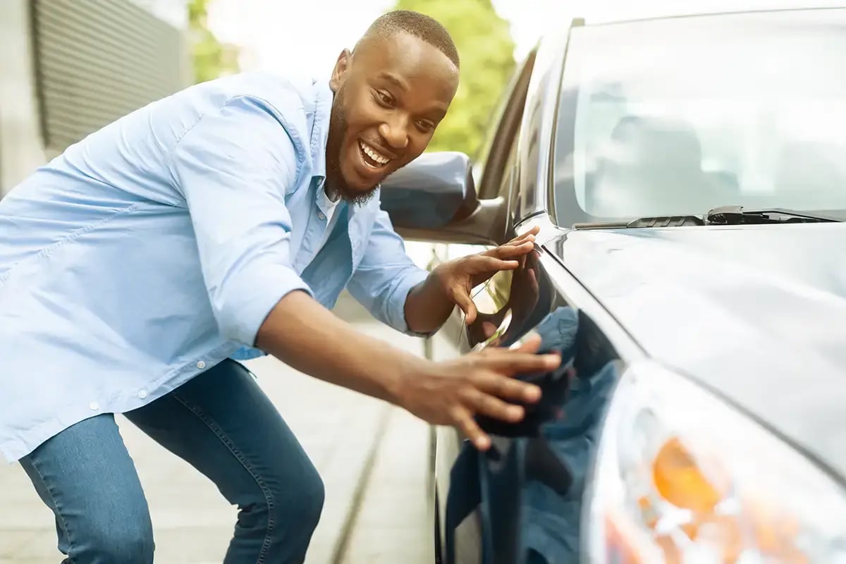 Man happily checking out his shiny clean car