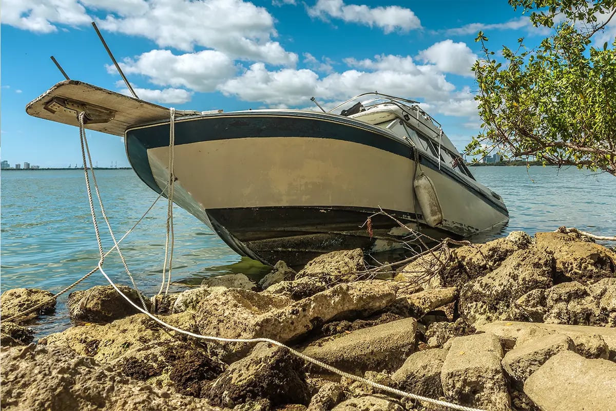 Boat stranded on rocks showing need for mechanical breakdown protection.