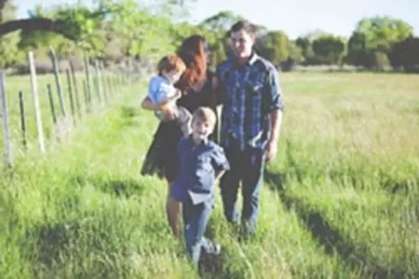 Family standing on their new property financed through a Radiant Credit Union land loan, taking the first step toward their dream home.