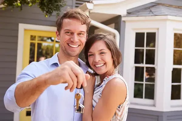 First time homeowners outside their new home financed by Radiant Credit Union