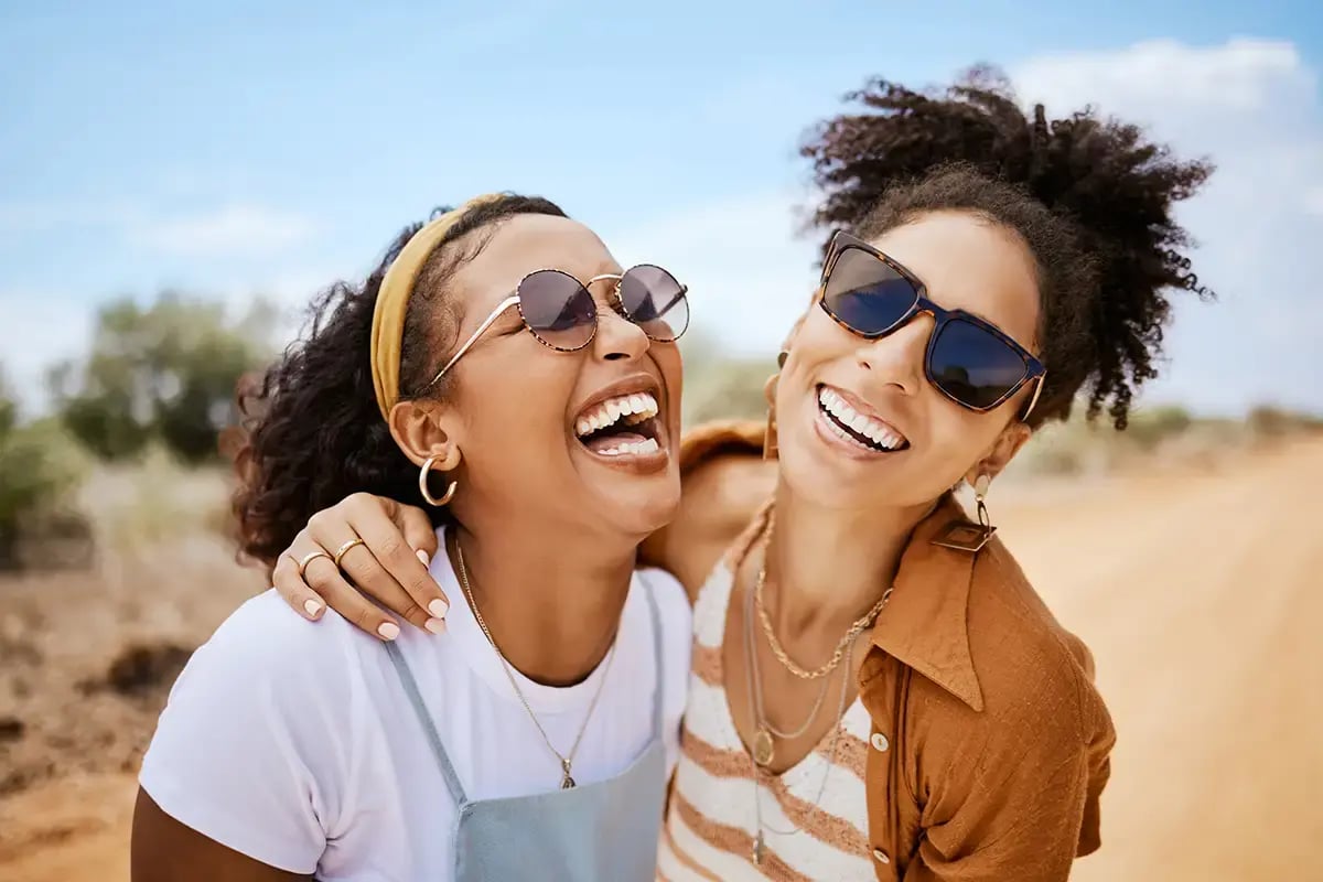 Two smiling friends happy because they just each received $50.