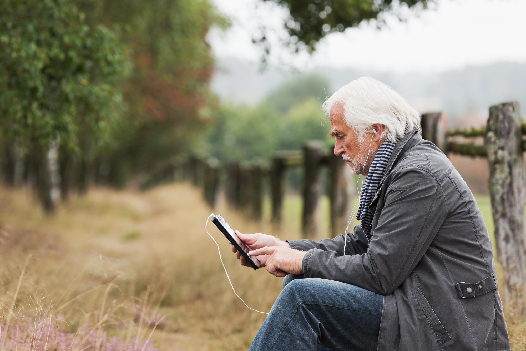 Older man checking his online banking tools from a remote spot, highlighting convenient anytime, anywhere account access.