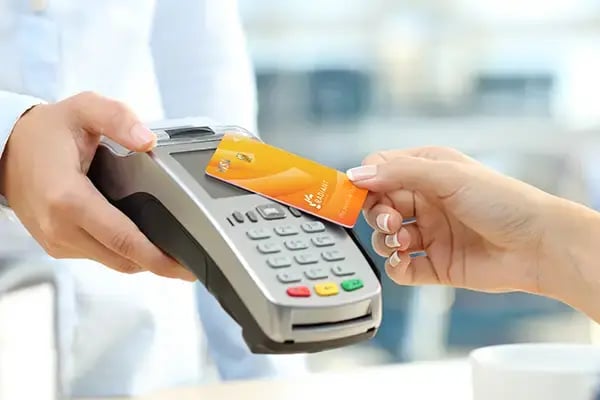 Person tapping a Radiant Credit Union secure credit card for fast, secure contactless payment.