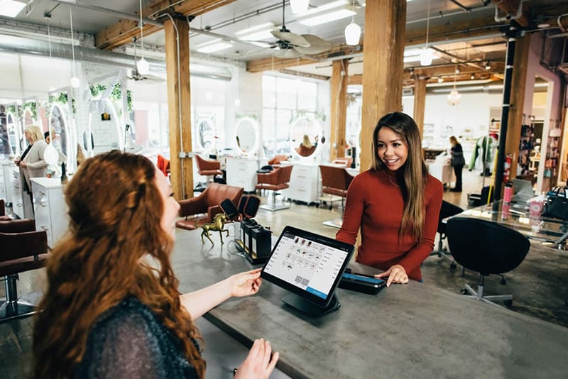 Woman checking out with a Radiant Credit Union debit card that offers rewards for everyday purchases at her local shop.