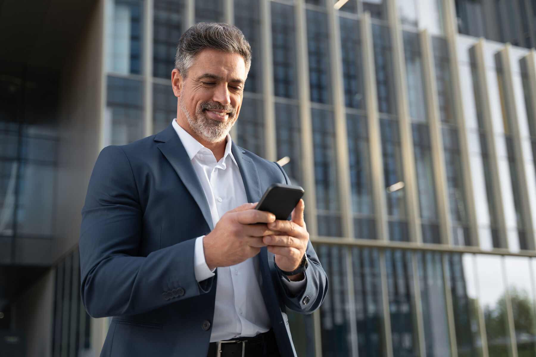 Businessman reading a Radiant Credit Union fraud prevention message on his phone, ensuring secure account monitoring.