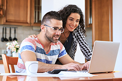 A man and woman excited looking at laptop