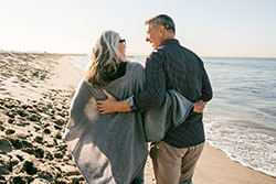 man and women walking on the beach