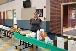 Traci standing behind table with food for teachers