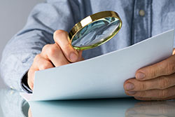 magnifying glass examining a paper