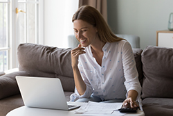 happy young woman looking at laptop